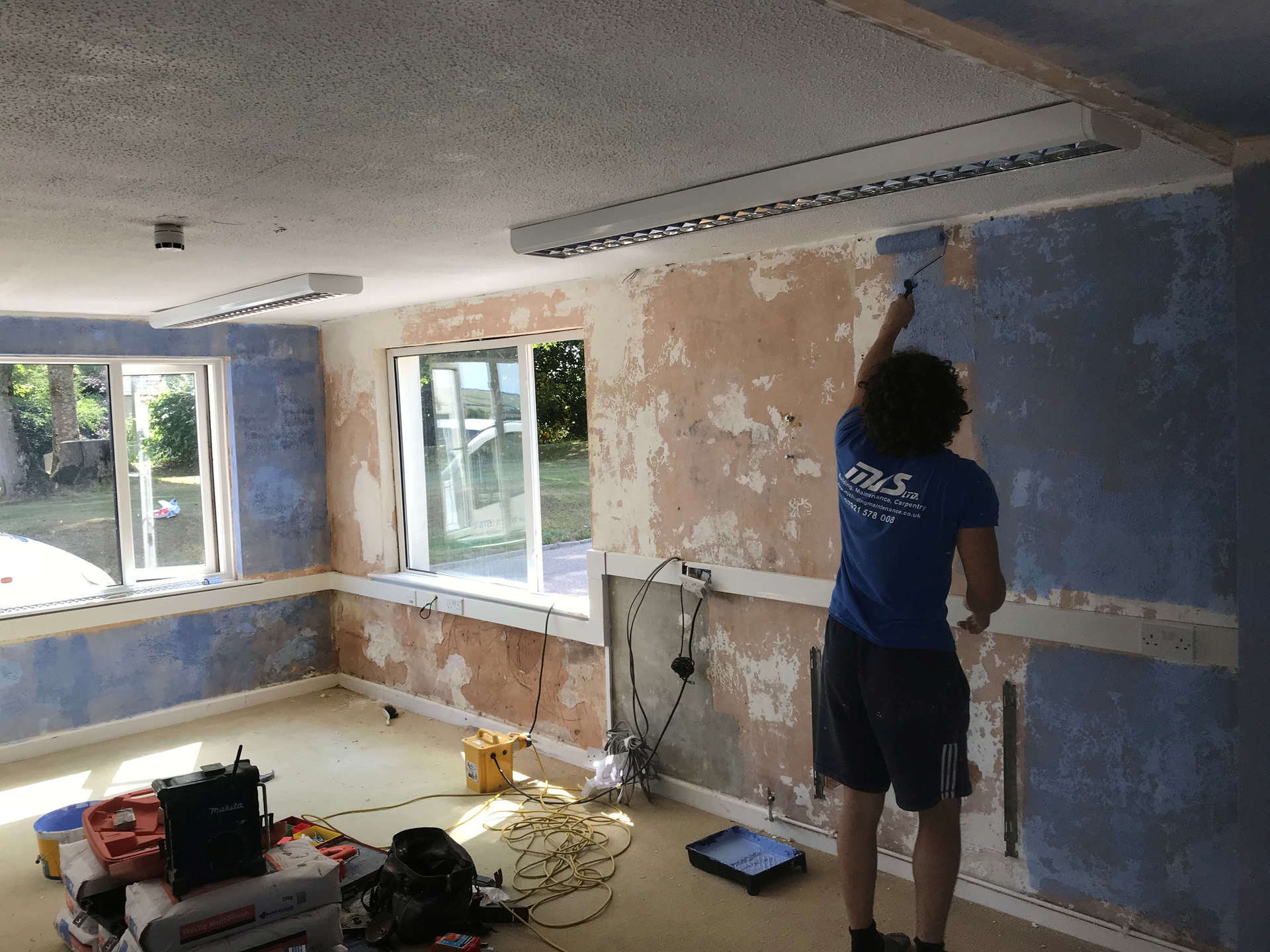 Refurbishment of classroom during summer holidays, walls stripped down to existing plaster. 