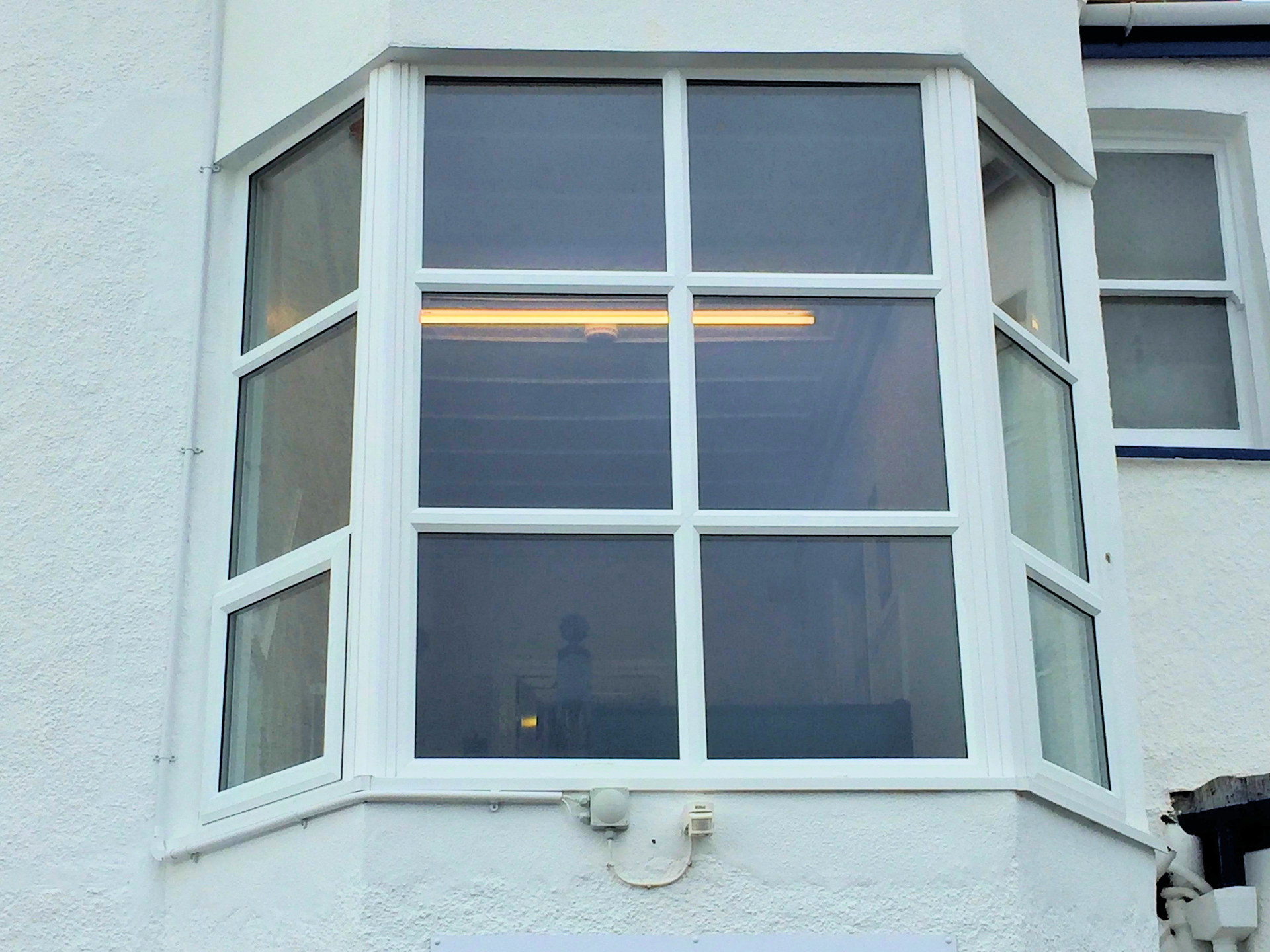 Bay Window, installation of uPVC window, patch in scat and render work on the outside and decorated white. Barnstaple North Devon