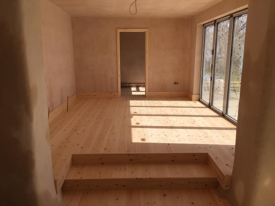 Pine wooden floor fitted, with some tight scribes around the plaster walls. North Devon